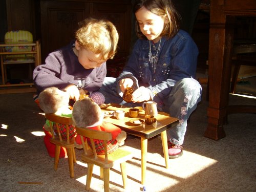 Zwei Kinder sitzen am kleinen Tisch
